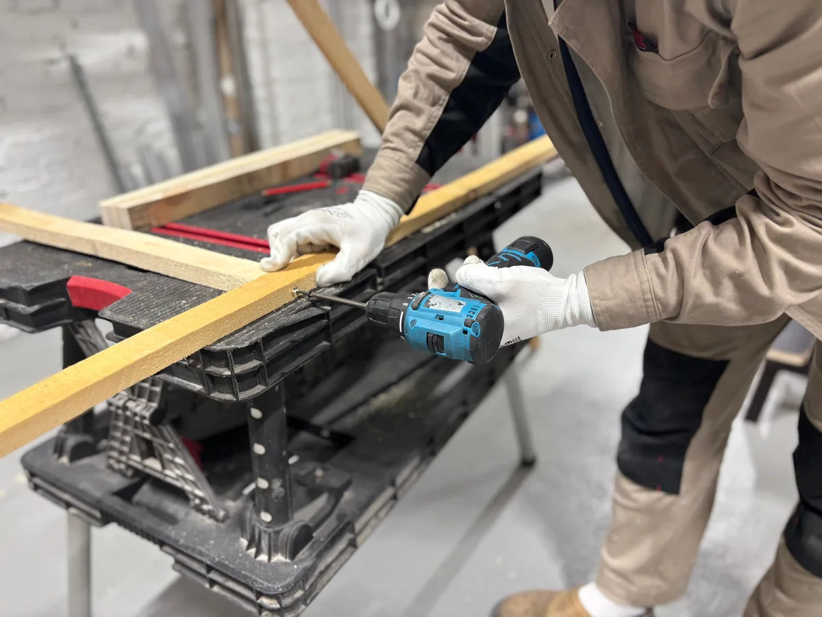 Technician applying vapor-control adhesive while gluing down engineered wood over a moisture-tested Florida slab