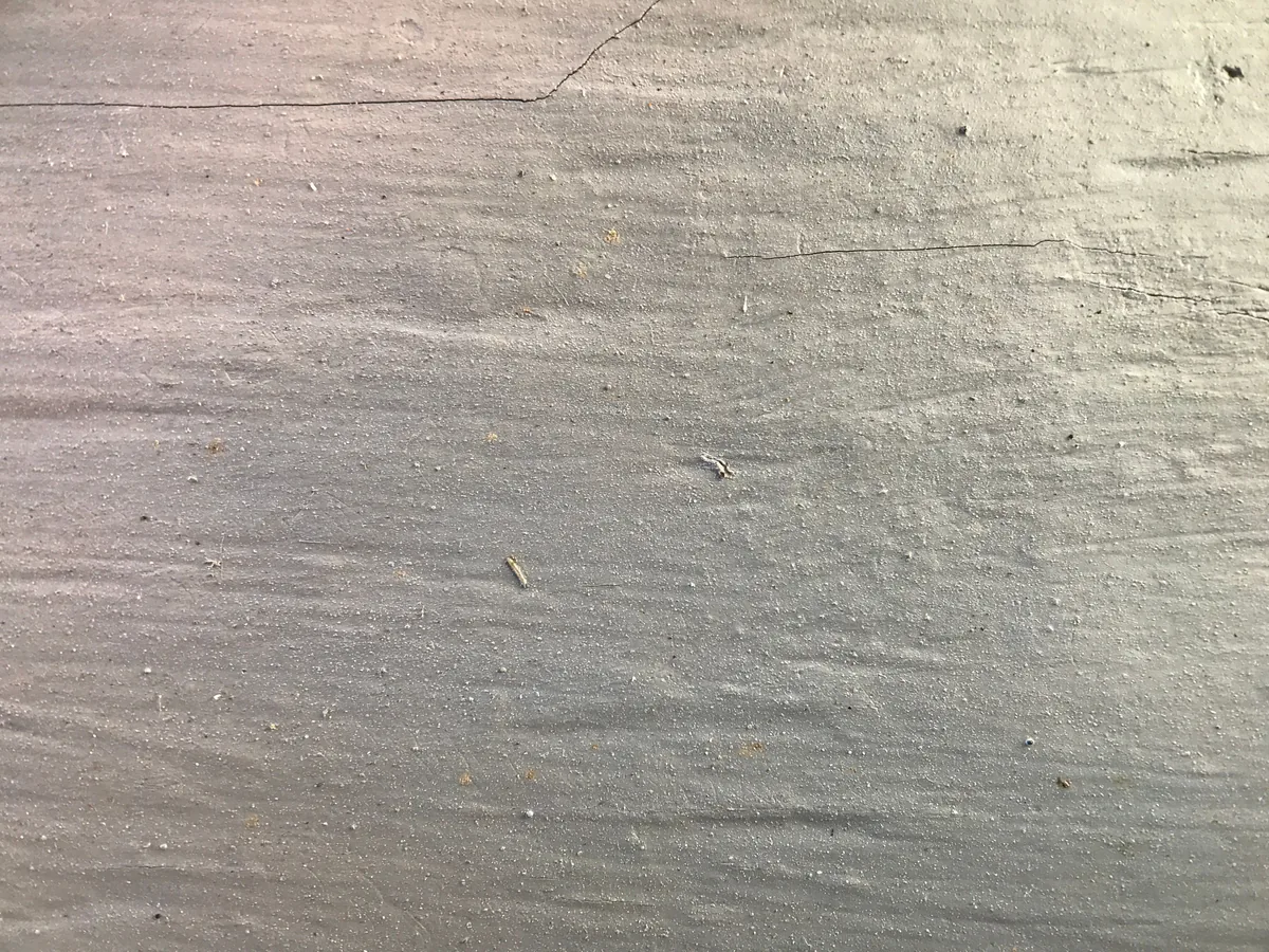Layers of a garage floor coating system — primer, decorative flake broadcast, and a clear UV-stable polyaspartic topcoat