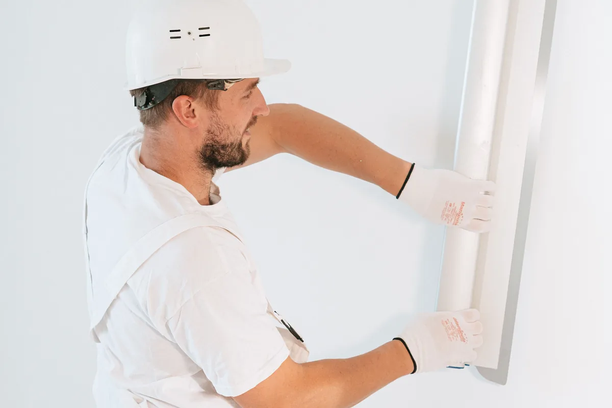 Technician moisture-testing a Florida kitchen slab and planning floor height against the dishwasher pocket
