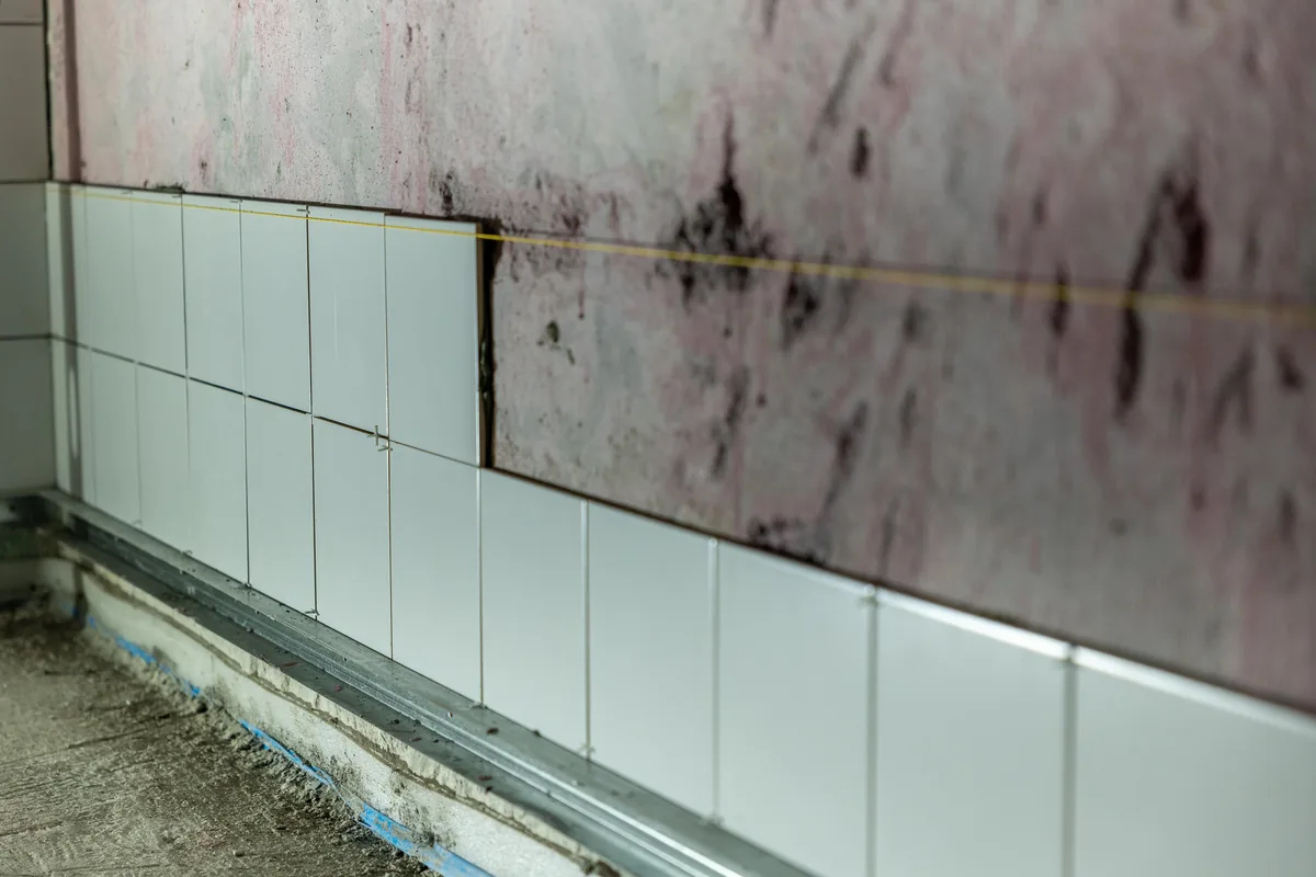 Installer applying penetrating sealer to honed marble tile in a coastal Florida home