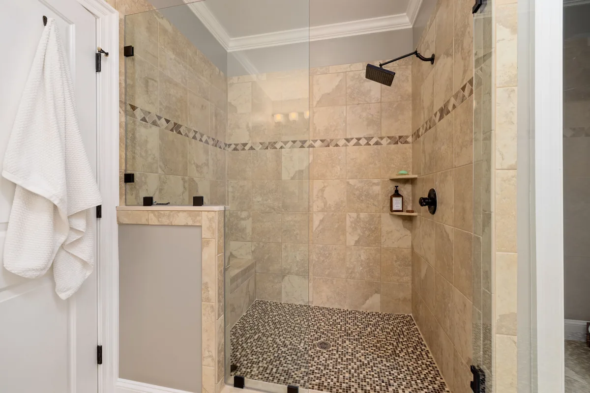 Cross-section of a Florida tiled shower showing sloped pan, bonded waterproofing membrane, and tile