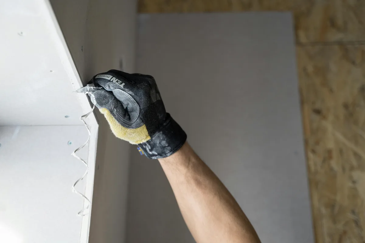 New mold-resistant drywall patch being taped and texture-matched into a Florida wall